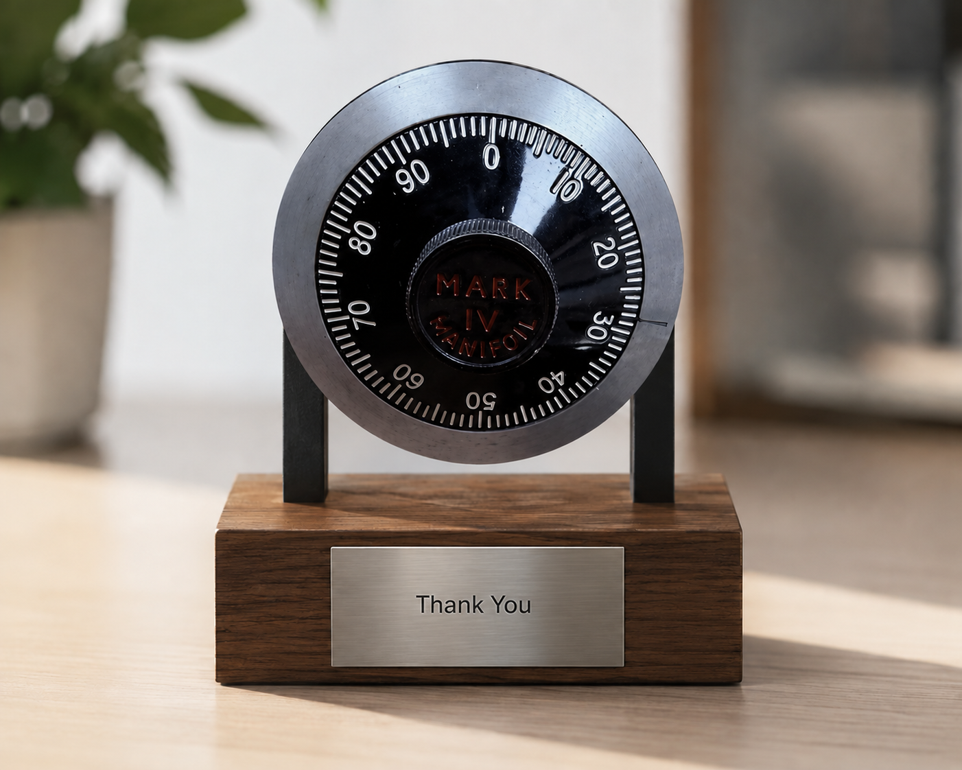 A retired combination lock mounted on a wooden stand with an engraved "Thank You" plaque, given as a leaving gift